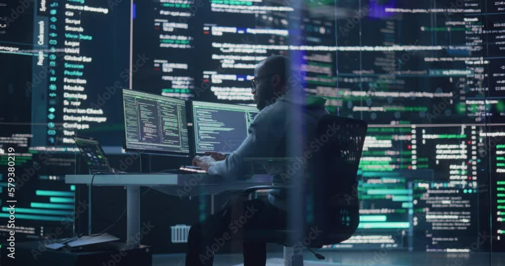 Leinwandbilder Black Male Developer Thinking and Typing on Computer, Surrounded by Big Screens Showing Coding Language. Professional Programmer Creating Software, Running Coding Tests. Futuristic Programming Concept