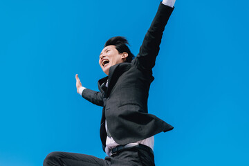 Fototapeta na wymiar 飛び跳ねて喜ぶ日本人男性ビジネスマン