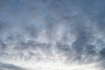 Cloudscape at dusk time with soft light gray clouds.