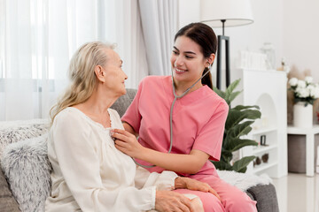 Fototapeta premium Young professional confident skilled woman doctor visiting old patient lady at home for treatment control care giving. Nurse talking to Caucasian senior patient. Healthcare concept