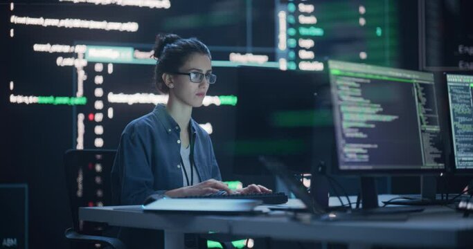 Female Programmer Working in Monitoring Control Room, Surrounded by Big Screens Displaying Lines of Programming Language Code. Portrait of Woman Creating a Software. Abstract Futuristic Coding Concept