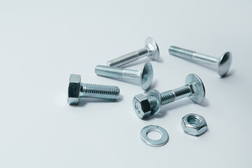 Close-up of various steel nuts and bolts. Mechanical, constructional still life. Nut and bolts on white background.