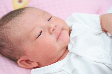 Portrait of a newborn Asian baby girl sleep on the bed , cute Fat baby 5 day,close up.