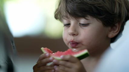 Small boy eating watermelon fruit. Child eats healthy snack food