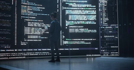 Back View Shot of Female Programmer Working in a Monitoring Control Room, Surrounded by Big Screens Displaying Lines of Programming Language Code. Portrait of Woman Creating a Software and Coding - Powered by Adobe