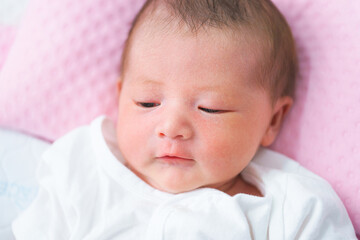 Portrait of a newborn Asian baby girl sleep on the bed , cute Fat baby 5 day.