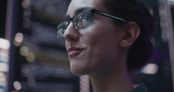 Close Up Portrait of Smiling Woman Looking Around, Lines of Code Language Reflected on her Glasses from Big Display Screens Surrounding her. Professional Female Programmer Developing Software, Coding