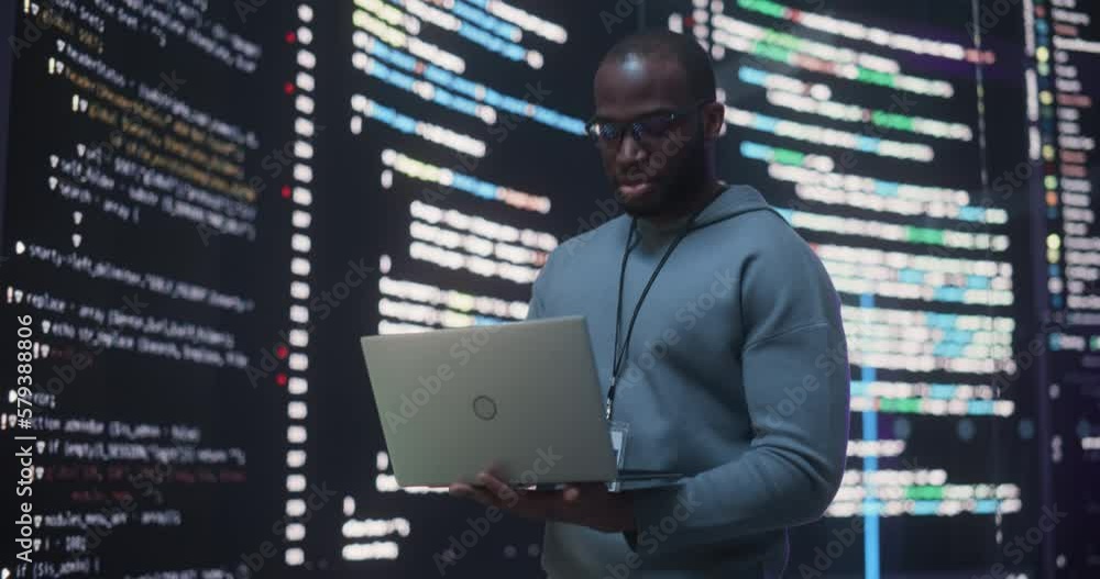 Aufkleber Portrait of Young Black Man Working on Laptop Computer, Looking at Big Digital Screen Displaying Back-end Code Lines. Professional Programmer Developing a Big Data Interface Software Project