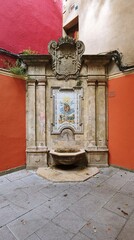 Ancient Spanish fountain in a corner on the street