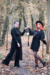 Two modern witches in autumn forest