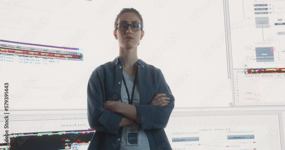 Leinwandbilder portrait of woman looking at camera and crossing arms with big digital screens glitching in the back