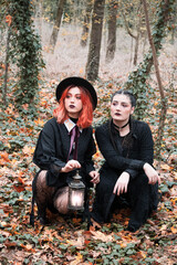 Two modern witches in autumn forest