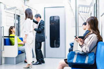 電車・地下鉄で移動する人々