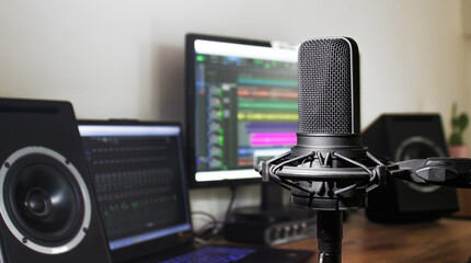 Professional vocal microphone and home recording studio with speakers and audio editing station for podcast production or radio broadcast. Music production or podcasting background with copy space 