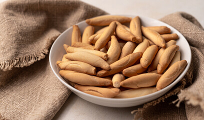 Bowl with picos - bread sticks on the beige background with textile napkin