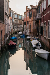 Charming view of a canal in Venice, Italy with boats docked alongside 