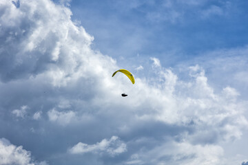 Paragliding concept, paraglider pilot fly in sky on beauty nature mountain landscape Norma Italy famous resort in paragliding flights. horizontal photo in the sky