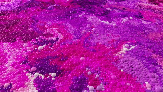 Abstract liquid video background 4k.  3d rendering of spherical particles moving in multicolored swirling flows. Magenta and violet bubbles balls  floating in colorful intertwining mixing streams.