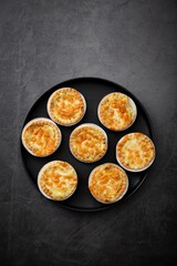 Vertical top view of little pot pies served on a black tray