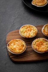 Vertical closeup of little pot pies served on a wooden tray
