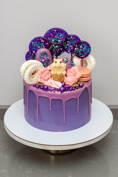 Birthday party cake with chocolate mouse on the top. Decorated with lollipops, meringues and candies.