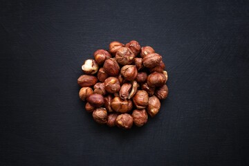Top view of hazelnut seeds shaped as a circle on a black background