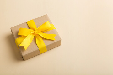 Wrapped christmas or other holiday handmade present in craft paper with colored ribbon. Present...