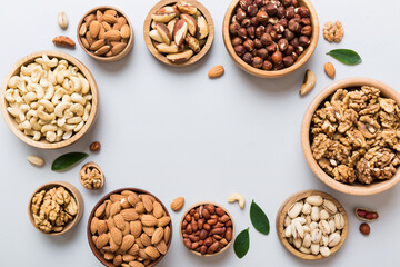 mixed nuts in wooden bowl. Mix of various nuts on colored background. pistachios, cashews, walnuts, hazelnuts, peanuts and brazil nuts
