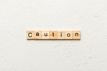 CAUTION word written on wood block. CAUTION text on cement table for your desing, concept