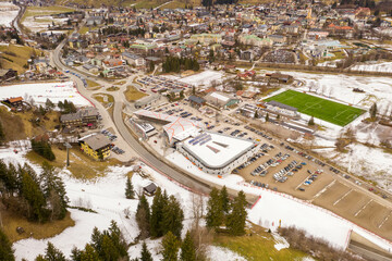 Drone photography of mountain alp town in mountain valley and ski lift station during cloudy winter day