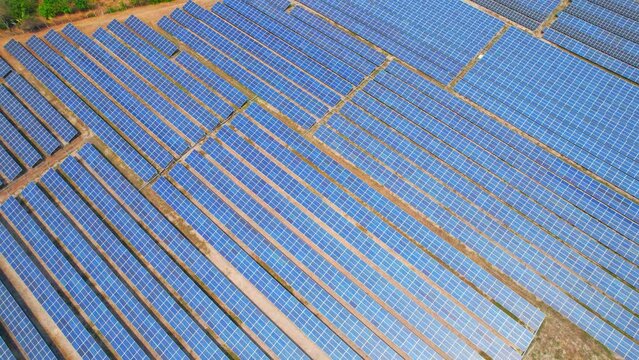 Aerial view drone shows rows of solar panels arranged in a large open space, each panel with a rectangular shape and reflecting sunlight. energy and technology concept. High quality video footage

