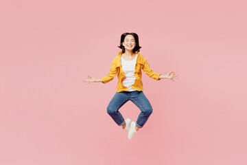 Full body young woman of Asian ethnicity wear yellow shirt white t-shirt jump high hold spread...