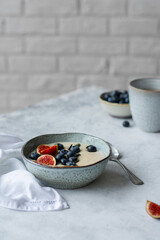 Semolina porridge decorated with blueberries and figs. Healthy breakfast with porridge, fruits and coffee. Food photography