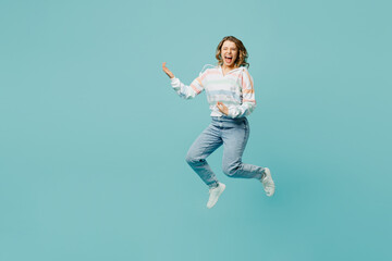 Full body young overjoyed excited happy fun woman wearing striped hoody jump high hold hands pov playing guitar isolated on plain pastel light blue cyan background studio portrait. Lifestyle concept.