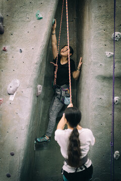 Two Young Asian Girls At Indoor Rock Climbing