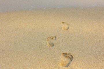 Keep walking and moving forward concept, Footprints of human feet walk on the white sand beach, Structure of feet marked on very fine sand, Surface and texture with free copy space, Nature background.