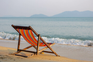 Vacation concept, Colourful canvas stretcher or beach chairs on the white sand beach with blurred...