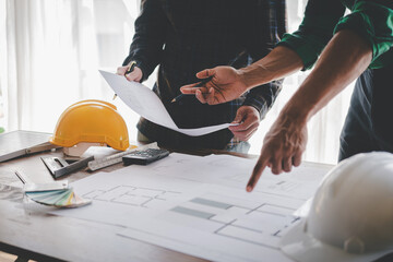 Engineers work as a team with blueprints for architectural plans. Engineer sketching construction project concept with architect equipment Architects talking at table Teamwork and construction concept