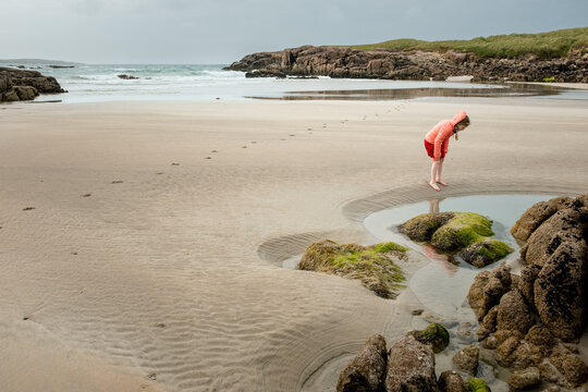 7 year old Girl Looking at a Rockpool on a Beautiful Beach in Donegal, Ireland