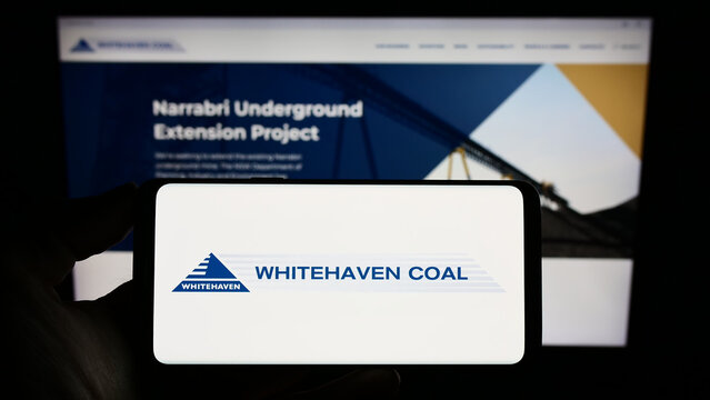 Stuttgart, Germany - 03-07-2023: Person holding smartphone with logo of mining company Whitehaven Coal Limited on screen in front of website. Focus on phone display.