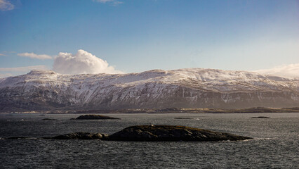 Snow covered Mountains surrounded by fjords in Norway during winter with icy mountain tops