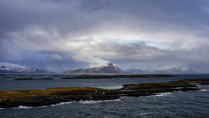 Snow covered Mountains surrounded by fjords in Norway during winter with icy mountain tops