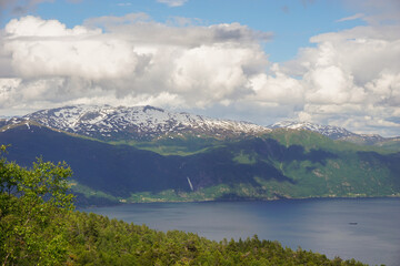 Scenic lake surrounded by mountains and forest on a sunny day