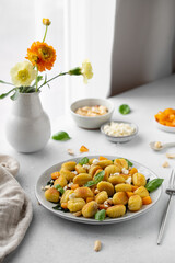 Fried Italian potato gnocchi with cheese and herbs on a white background. Italian food