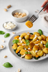 Fried Italian potato gnocchi with cheese and herbs on a white background. Italian food