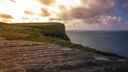 Stone Cliffs in Ireland on a cloudy day with a beautiful sunset by the ocean in spring