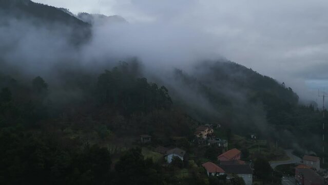 Aerial shot of Caldas de Gerez in a cloudy day full of fog surrounded by the valley, in Peneda Ger&ecirc;s, Portugal