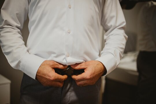 Groom fixing his belt for preparation of their wedding