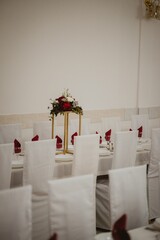 Vertical of the big tables decorated with flower bouquets prepared for the wedding ceremony