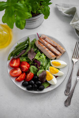 French salad Nicoise with tuna, eggs, green beans, tomatoes, olives. Top view.